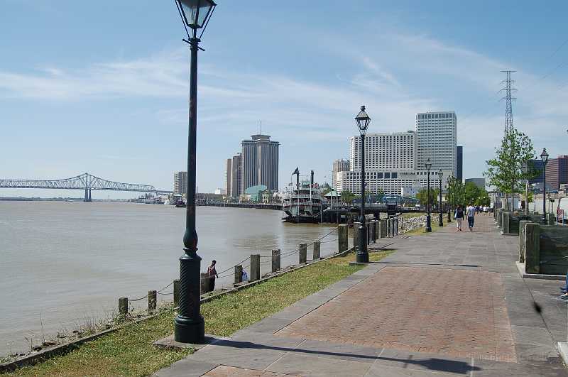 New Orleans 04-08-06 011.JPG - The Mississippi River, looking up-river.  The picture was taken from atop the river levee, which was not breached during Hurricane Katrina's visit.  The sloped green oval shaped roof is the Aquarium; hotels and casinos surround it.